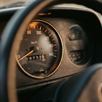 Close-up of a used car's analog odometer showing mileage